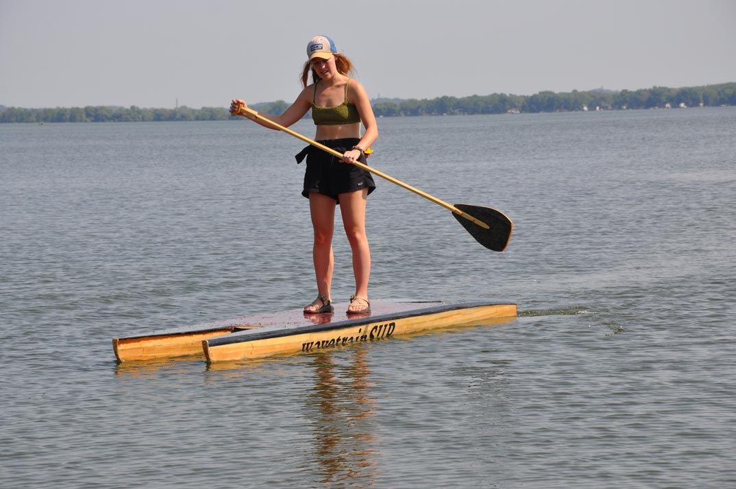 picture of a paddleboard featuring two pontoons and a deck.